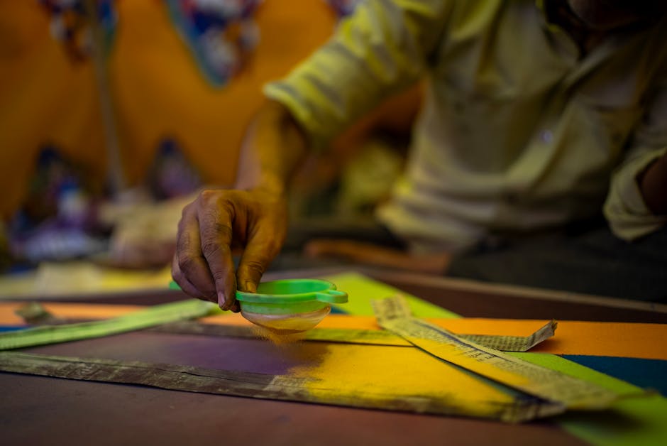 Hände halten einen Schöpfrahmen in der Pulpe beim traditionellen Papierschöpfen